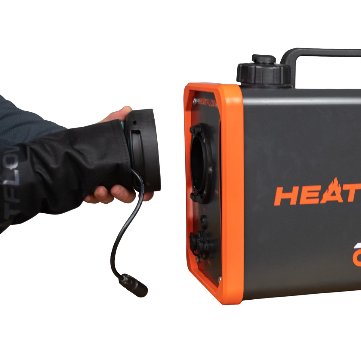 A black and orange portable heating unit shown next to a person's hand holding a hose connector, on a plain white background.