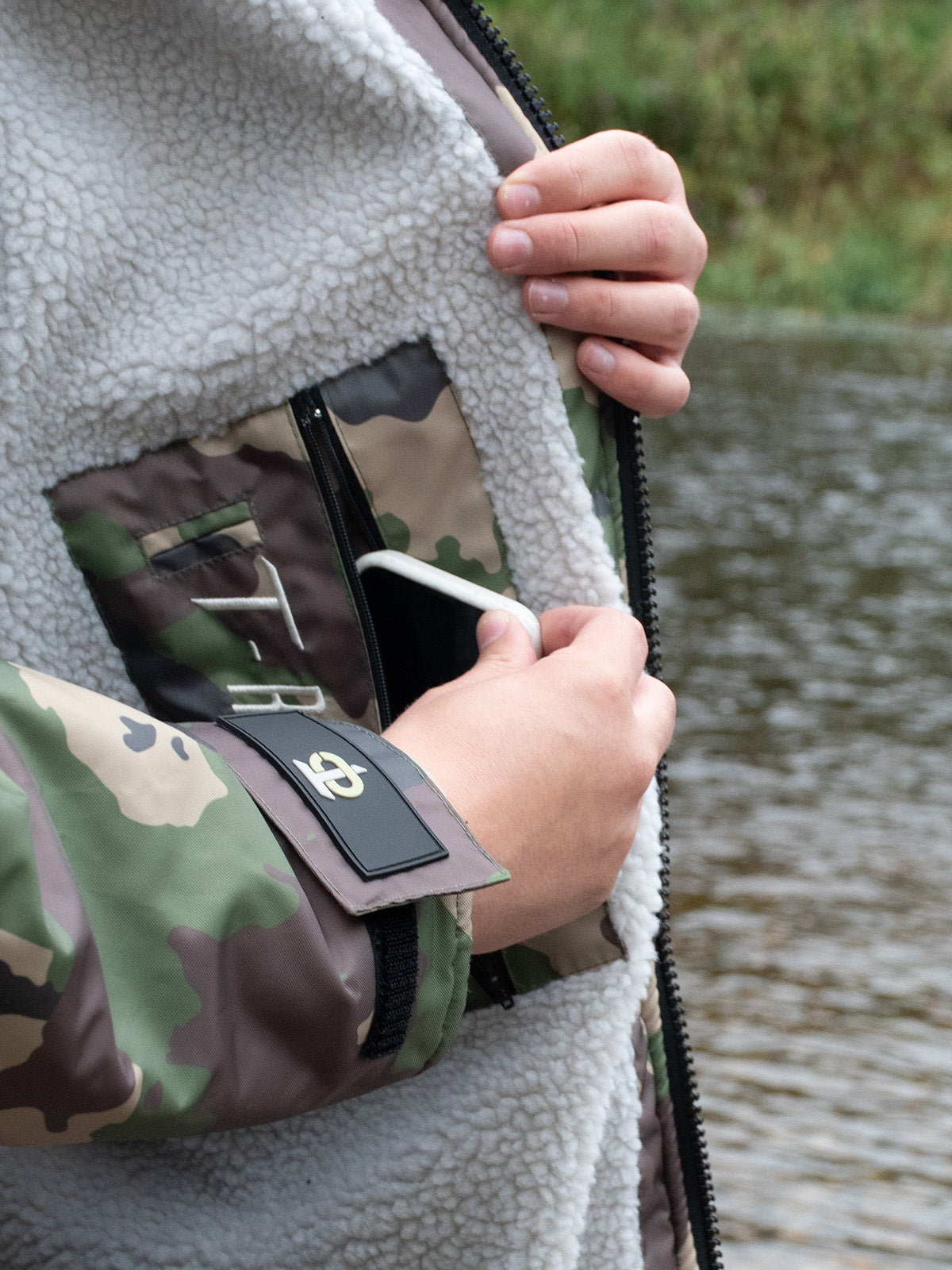 Image of someone placing their phone into the secure inner pocket of the T-Robe