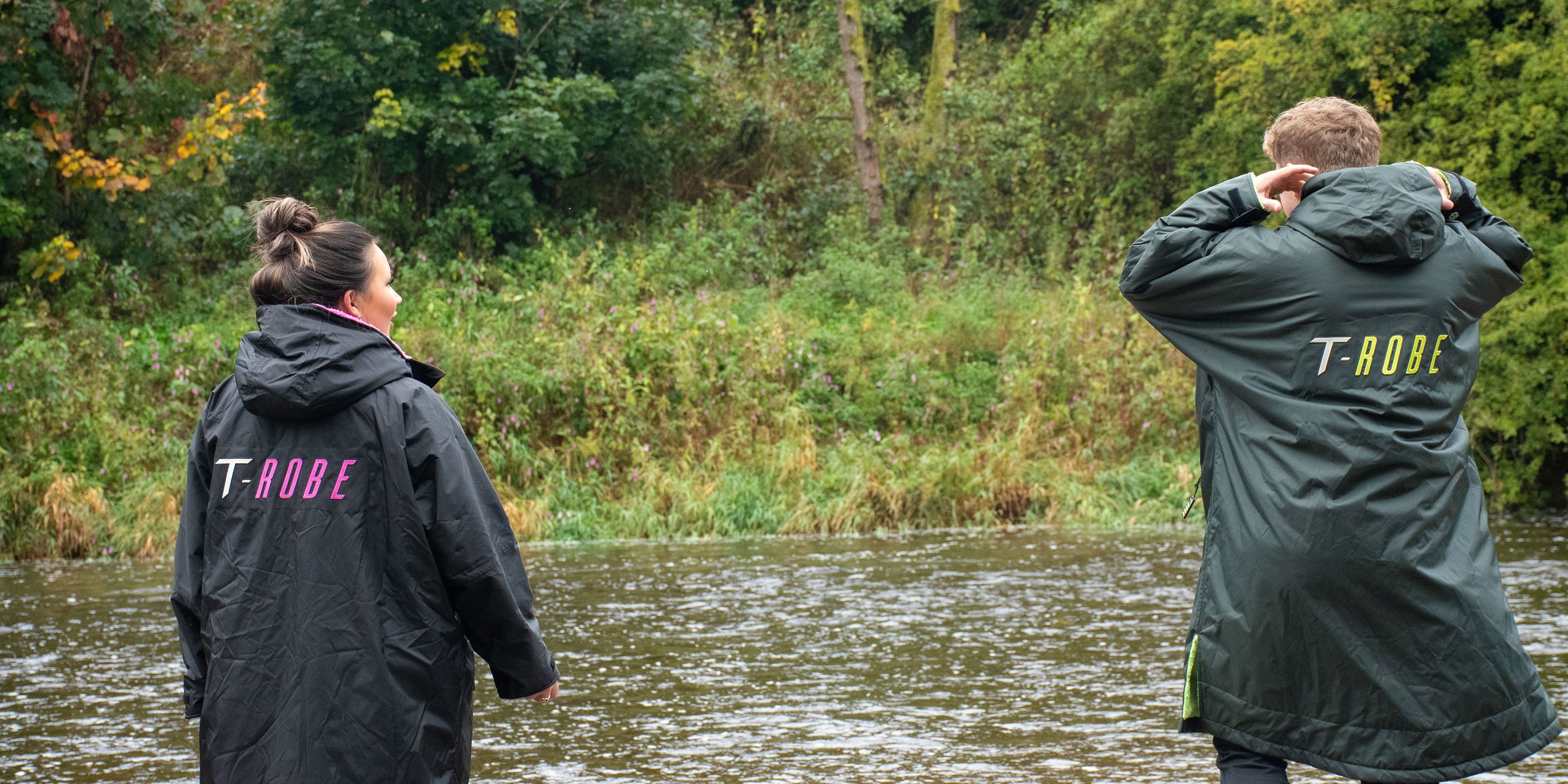 Image of a man and woman wearing changing robes next to a river