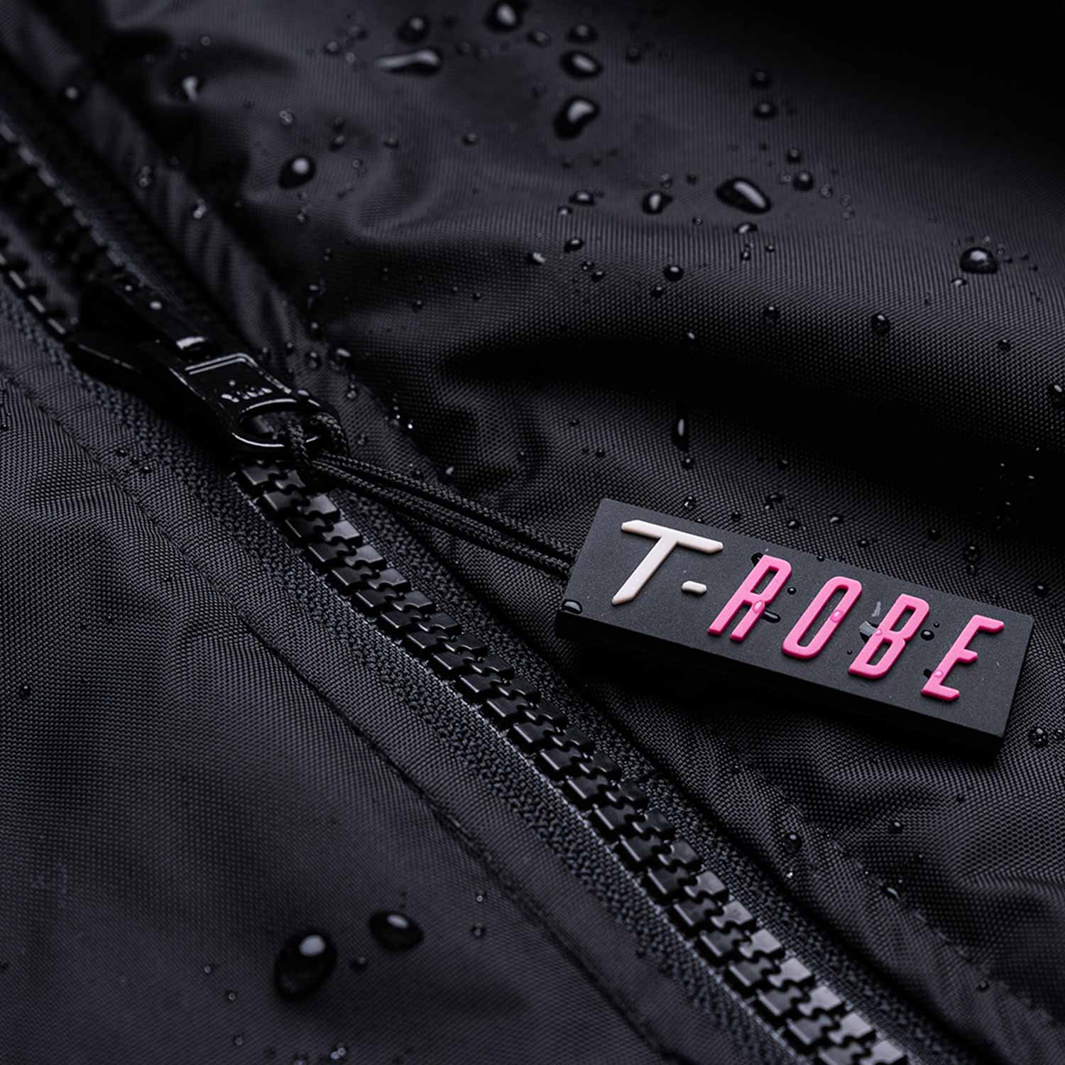 Image of water droplets on the surface of the black and pink T-Robe showcasing the waterproof capabilities