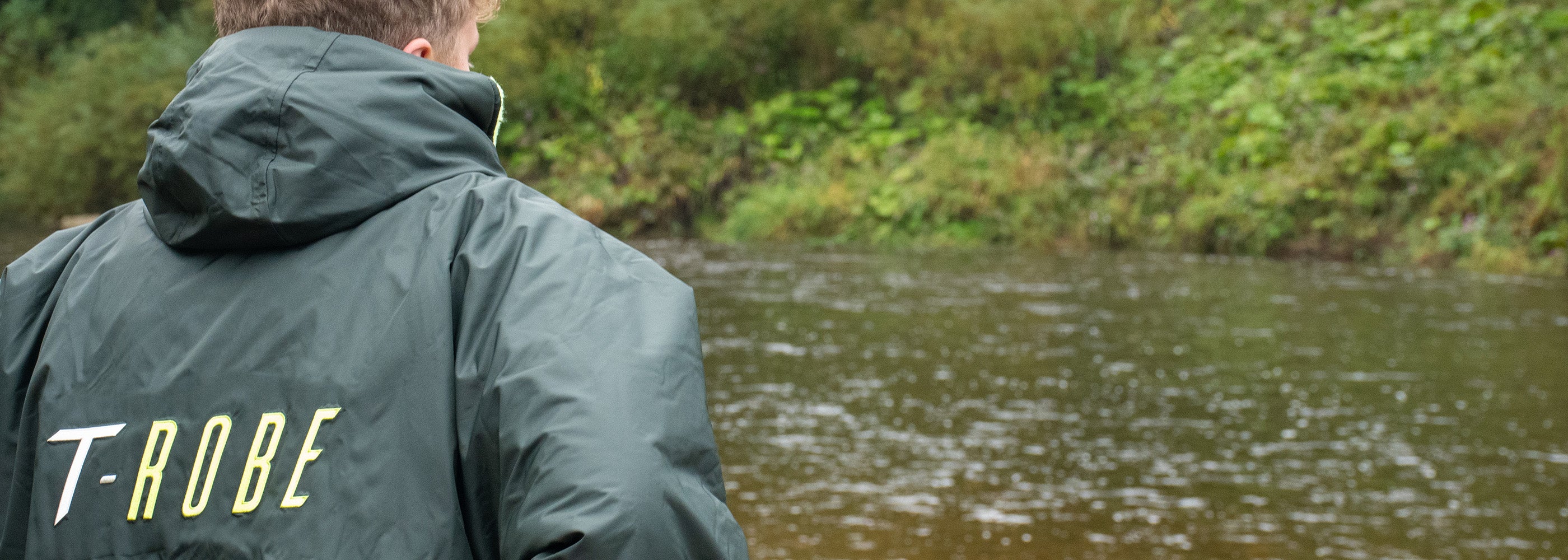 Close up image of a man looking out over a river whilst wearing a T-Robe