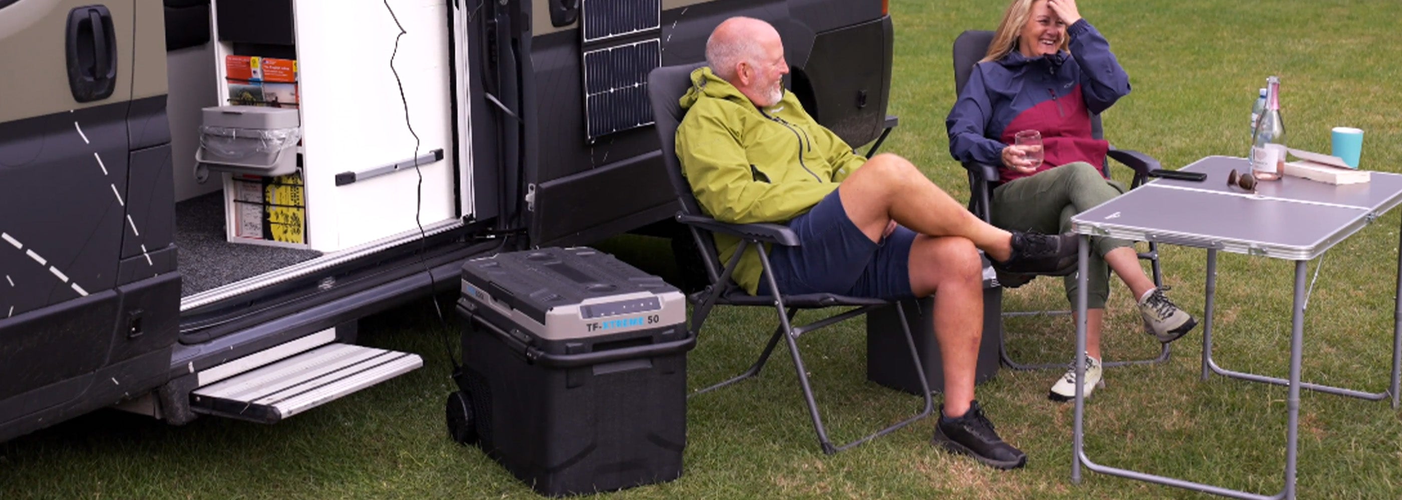 Lifestyle image of the TF-XTREME 50 outside of a motorhome with a man and woman enjoying chilled beverages